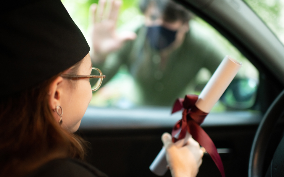Man congratulating teenage girl with graduation  in car